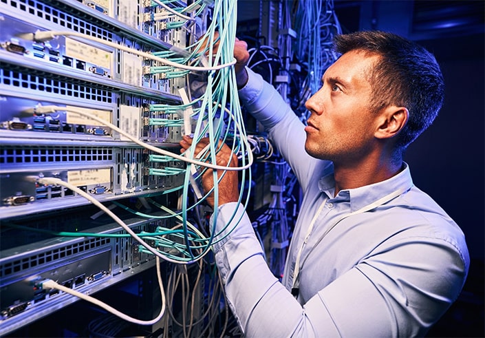 COMPLIANT AND PROFESSIONAL CABLING SOLUTIONS FOR UNMATCHED NETWORK PERFORMANCE AND ROI-min Man Working on Network Panel